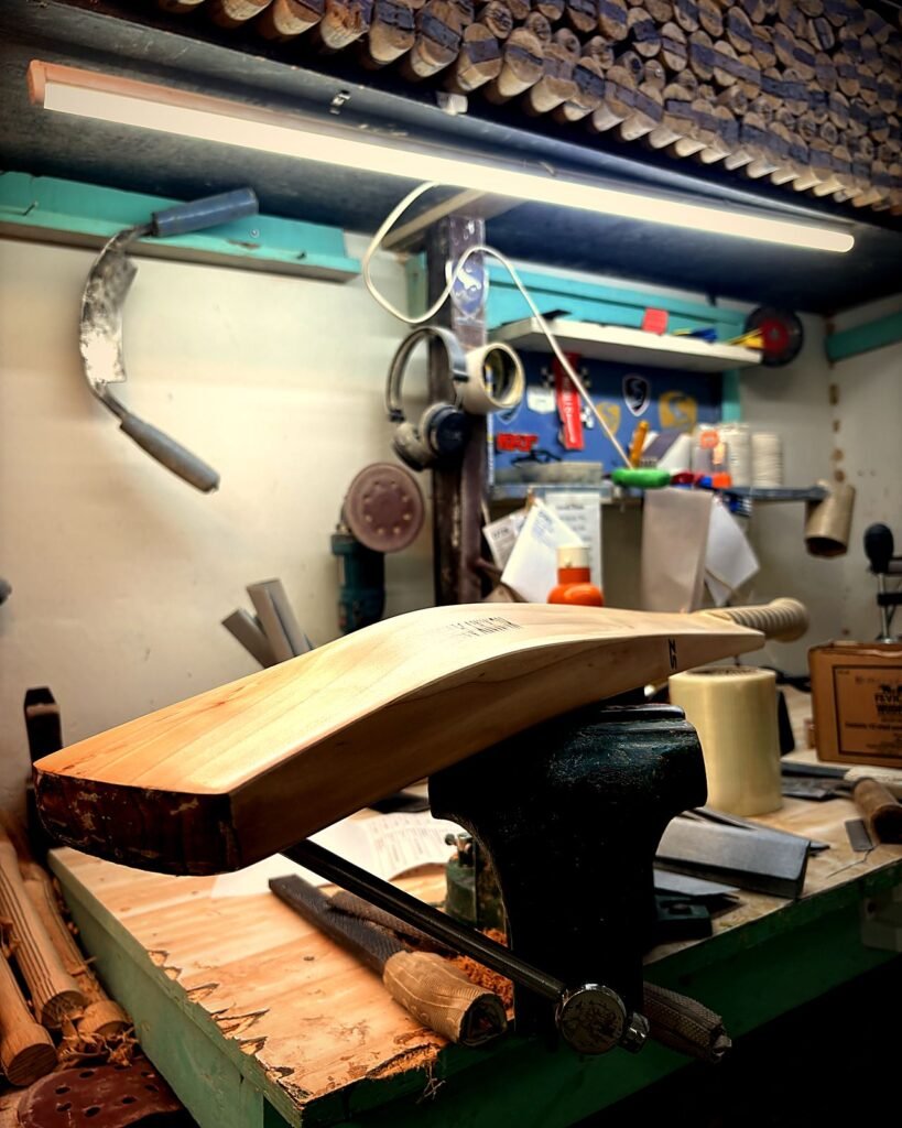 Cricket bat clamped in a vise at the Cricfix workshop, Patiala